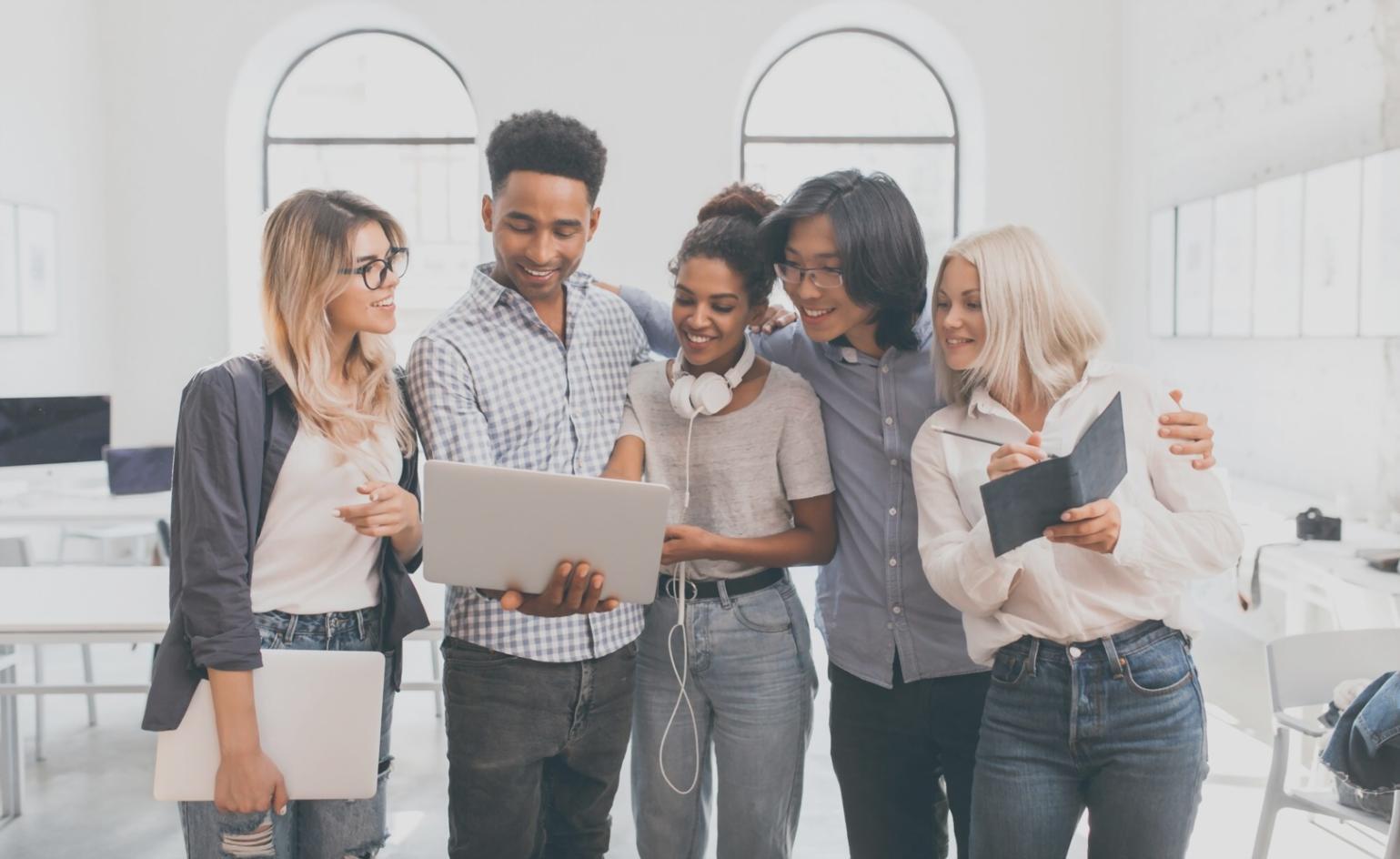 Financial documents and analysis reports spread across a desk with laptop showing property market data